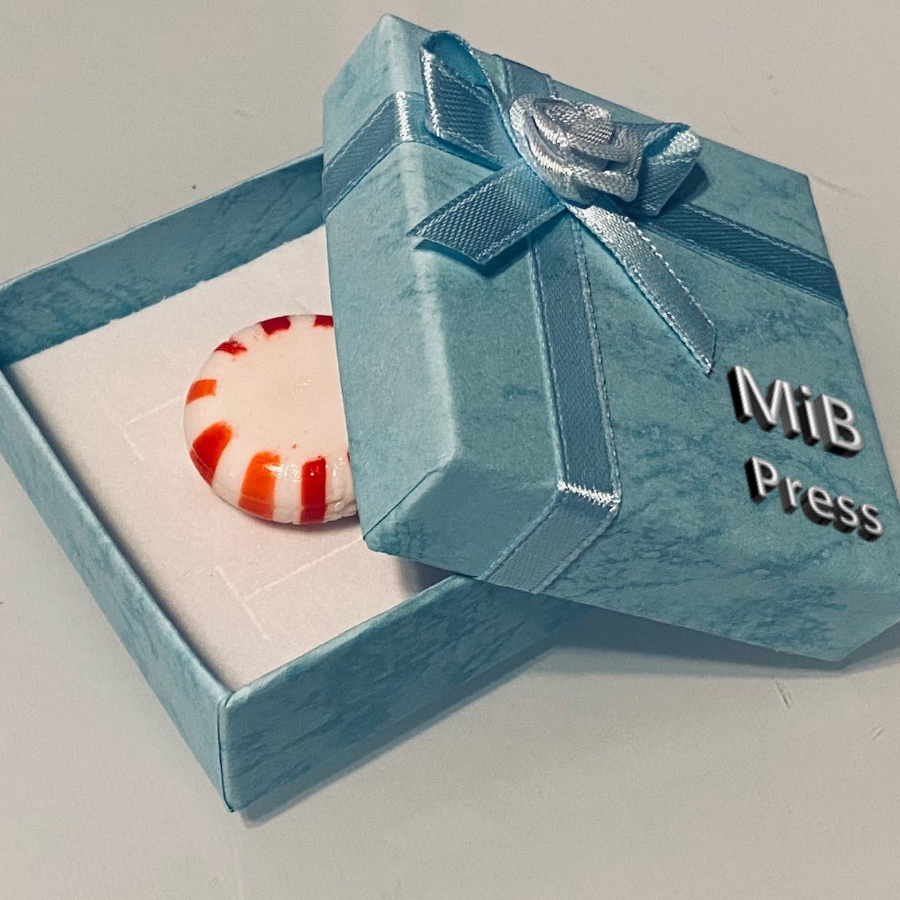 A mint green gift box with a ribbon and bow is shown, partially open, with a peppermint shown inside.